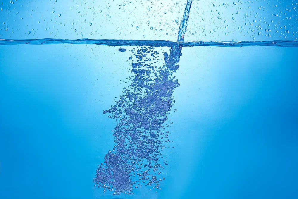 Blue water flow with bubbles
