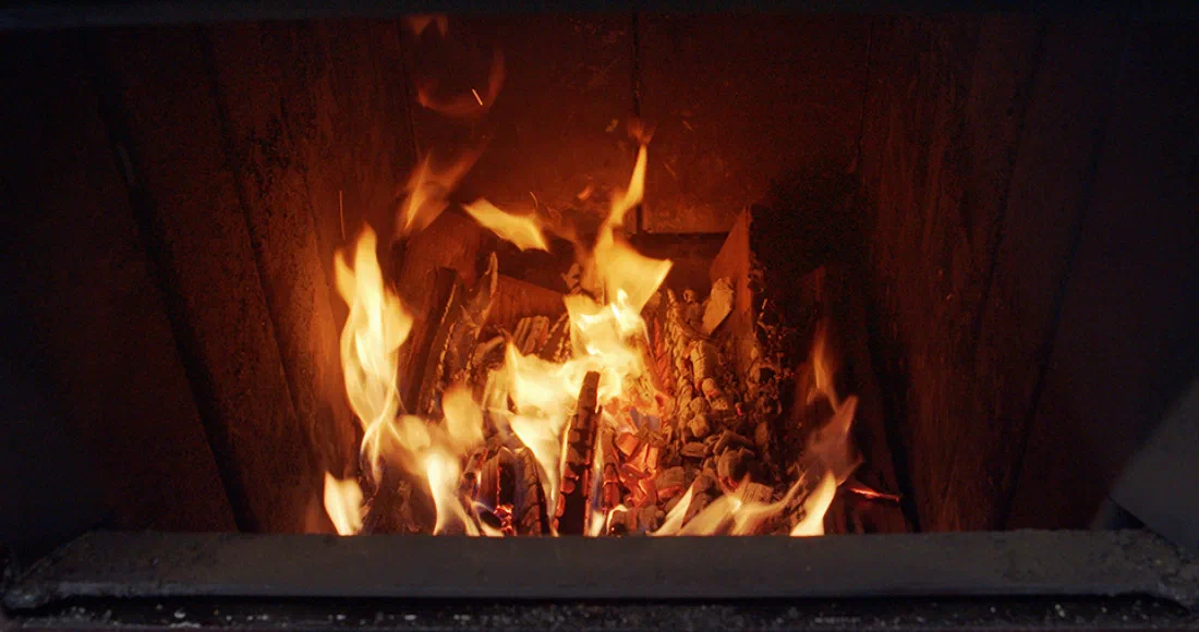 Burning logs in a wood boiler loading chamber